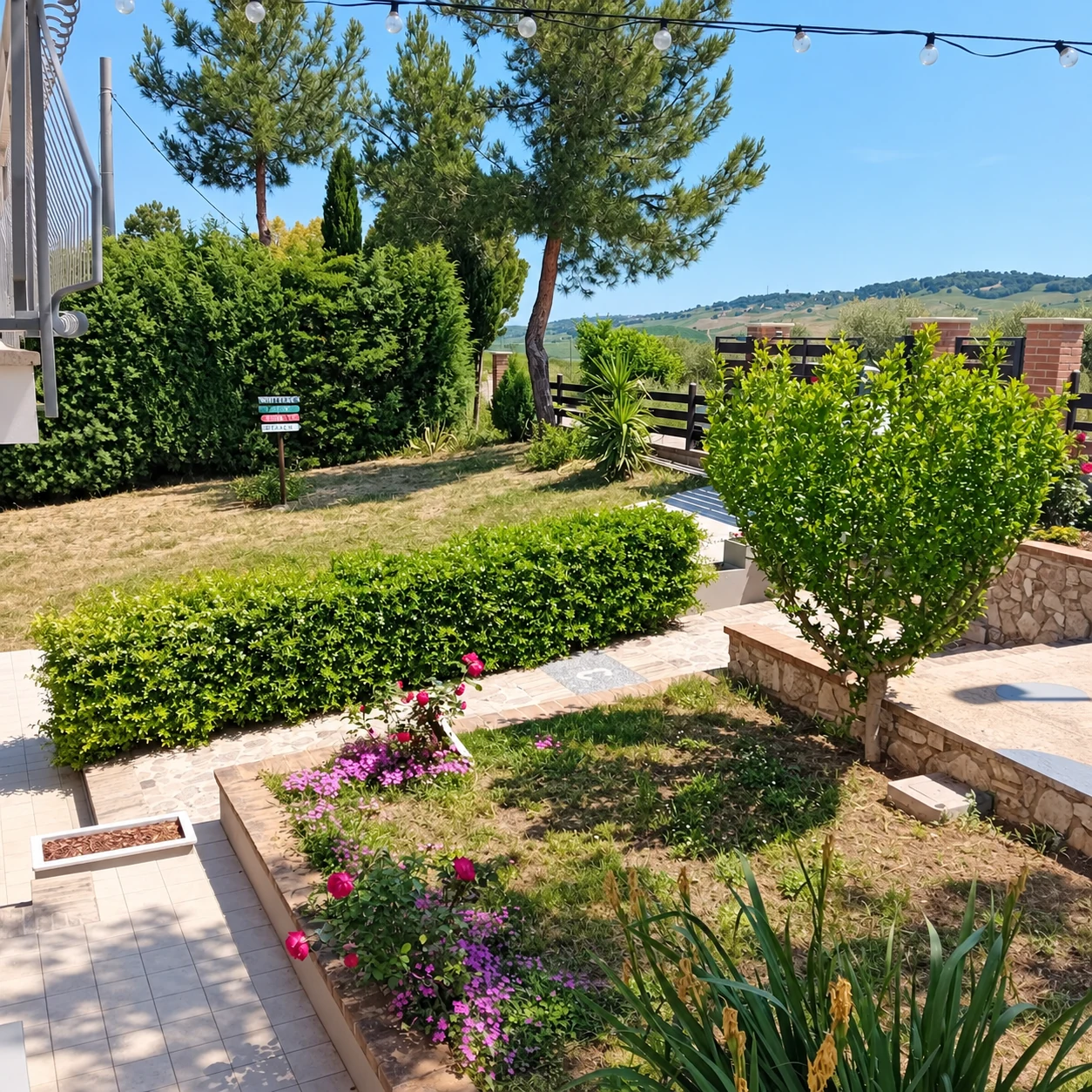 Il giardino recintato di Villa Nonno Nicola, con il prato e le colline