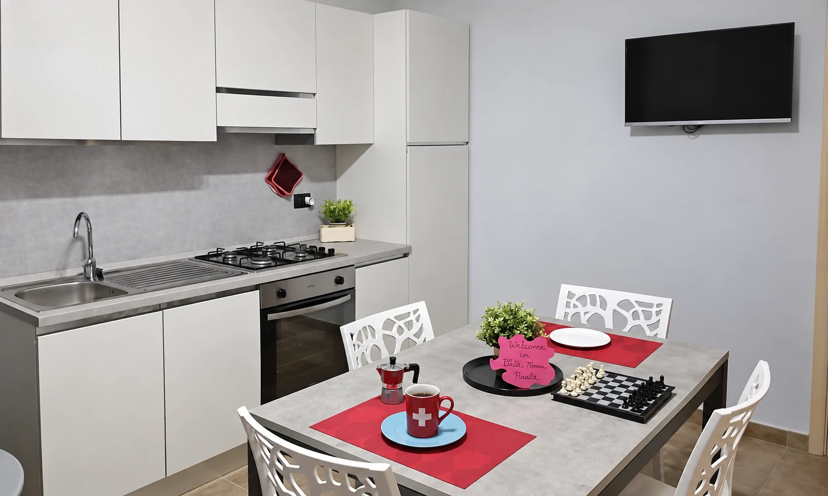Cucina con tavolo apparecchiato e televisore